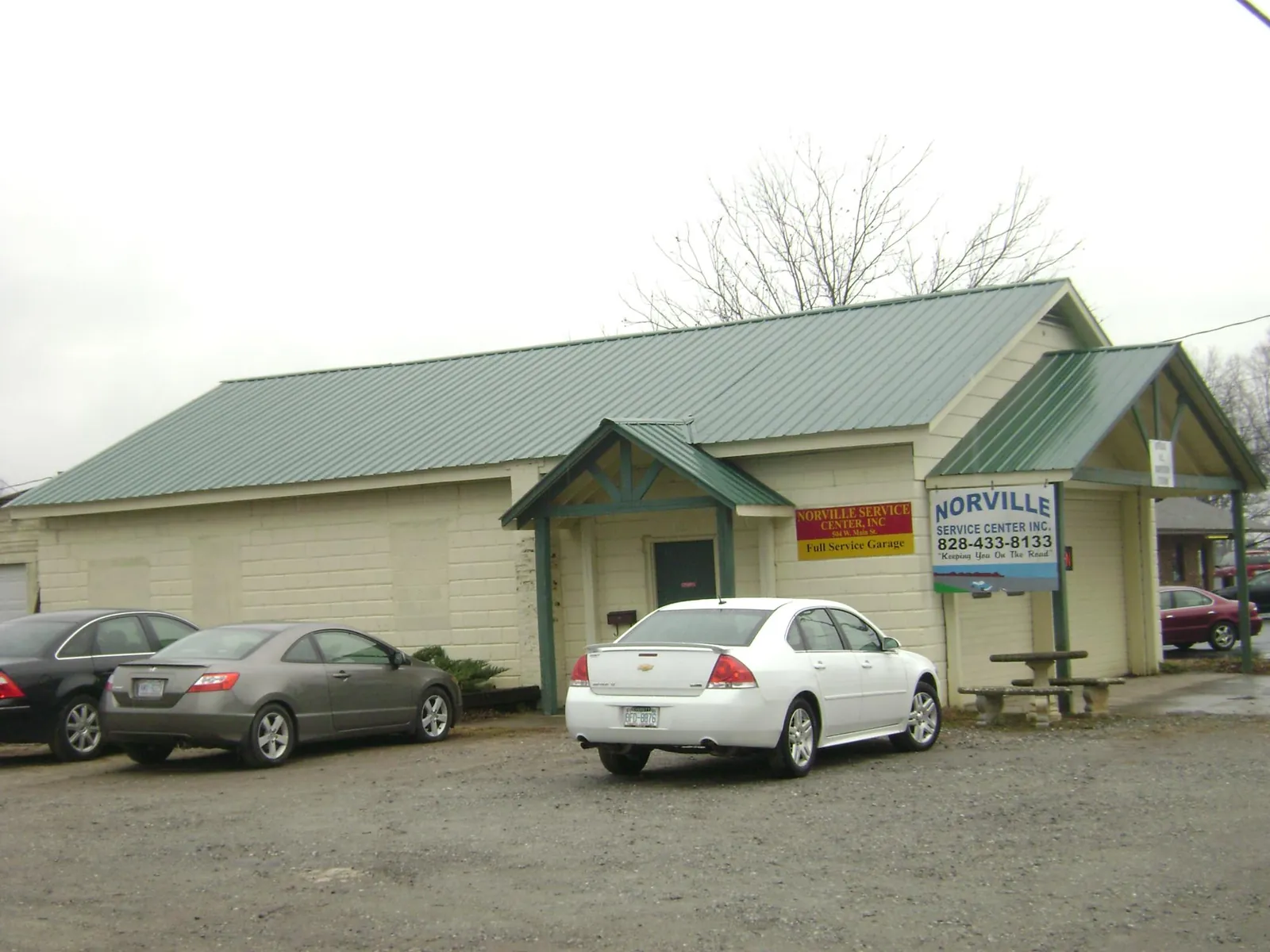 Green metal roof on a service garage with a covered entry in O Fallon
